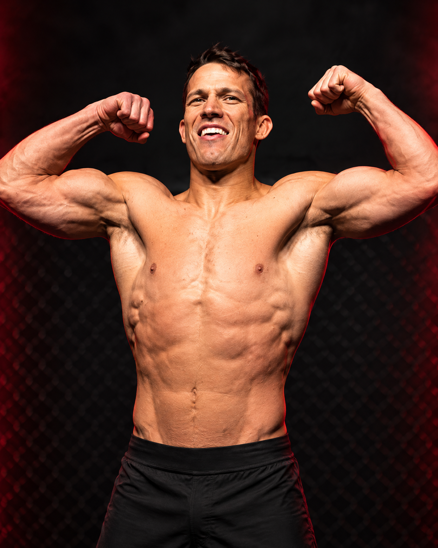 Standardized editorial portrait of Nate Mohr flexing against a dark gym background
