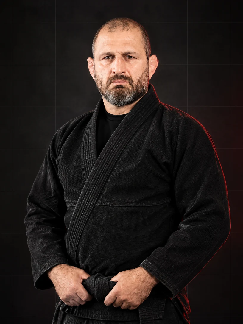 Source-faithful editorial portrait of Ralph Gracie in a black Brazilian Jiu-Jitsu gi